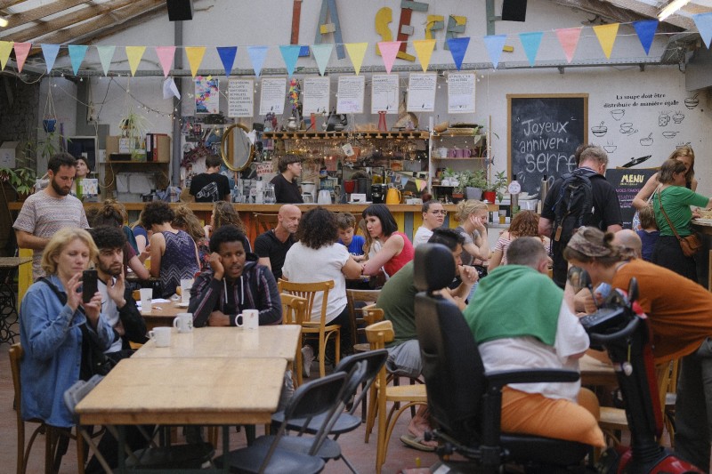 Many people doing different activities at the bar of a socio-cultural centre