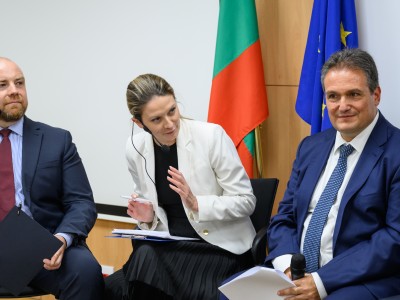 Three people speaking at a panel discussion, formal