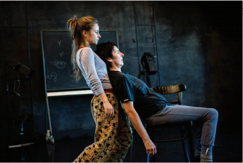 two people dancing against a dark background