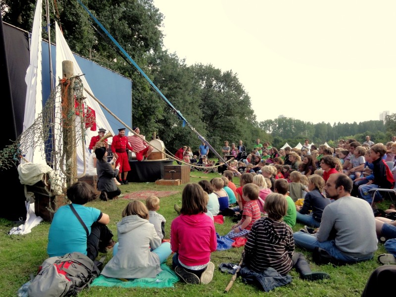 A group of people watch an outdoor show in a rural area